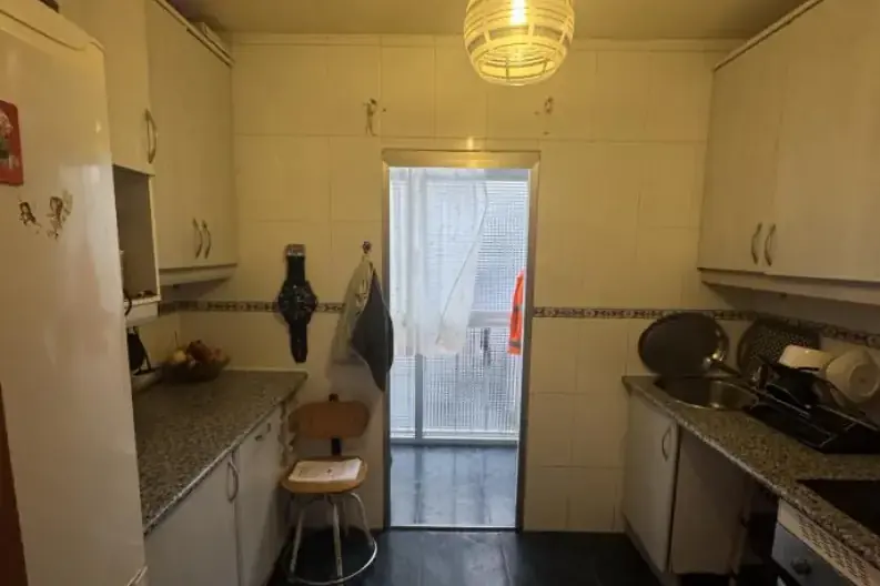 Cocina antes de la intervención: muebles deteriorados por una filtración de agua