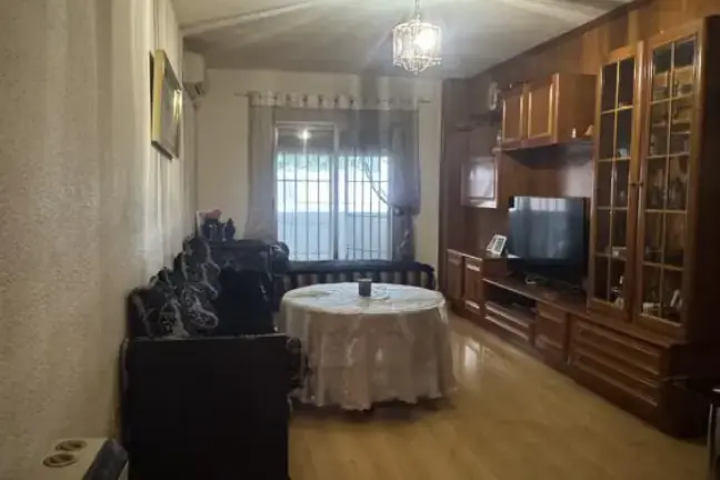 Salón antes de la puesta a punto: mural oscuro, poca luz y suelo antiguo